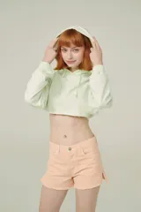 Buzo color durazno, corto, con capucha y mangas largas.