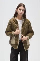 Campera acolchada de poliamida en color beige, con diseño de costuras en rombos, cuello alto, cierre frontal y bolsillos delanteros con solapa.
