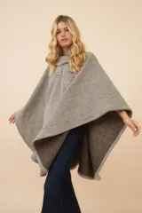 Poncho de lana fina con diseño de rayas diagonales, cuello camisero, cartera con botones a presión y bolsillo ojal en el pecho.