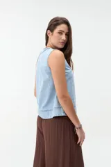Blusa sin mangas de denim claro, corte recto y escote redondo con costuras decorativas frontales.