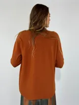 Sweater de punto color marrón, con cuello redondo, manga larga y diseño holgado.