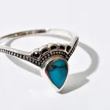 Anillo de plata con piedra turquesa en forma de lágrima.