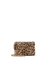 Cartera pequeña convertible con estampado animal print, correa de cadena dorada y cierre a presión.