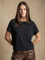 Remera negra de corte oversize, con mangas cortas y cuello redondo, confeccionada en tejido de viscosa y elastano de caída fluida.