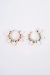 Caravanas tipo argolla de metal dorado, decoradas con pequeñas cuentas de colores y caracoles naturales colgantes.