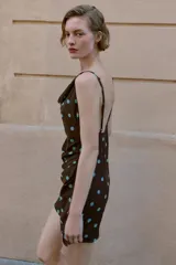 Vestido corto de escote fluido con tirantes finos ajustables. Presenta un diseño con frunces en la parte delantera y cierre lateral con cremallera oculta.
