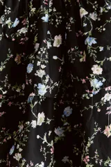 Vestido corto negro con estampado floreado, escote cuadrado con volados en los tirantes, cuerpo fruncido tipo nido de abeja y falda de capas escalonadas.