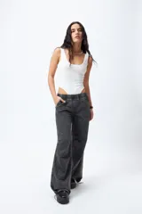 Pantalón jean ancho color gris oscuro, con elástico en la cintura, cordones ajustables en los bajos y grandes bolsillos laterales y traseros.