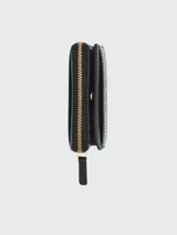 Billetera compacta Marc Jacobs de cuero negro con cierre perimetral y broches dorados. El interior cuenta con múltiples ranuras para tarjetas y compartimento para billetes.