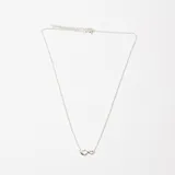 Colgante de cadena fina de plata 925 con un dije central en forma de símbolo de infinito.