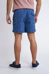 Short de baño con cintura elástica y cordón ajustable, confeccionado en tela ligera de secado rápido. Presenta un estampado botánico integral en tonos amarillos, blancos y azules, con dos bolsillos delanteros y uno posterior.