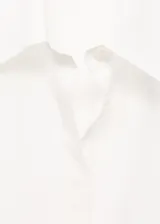 Camisa de lyocell color blanco, con cuello camisero, manga larga con puños abotonados, diseño recto y cierre frontal con botones ocultos.