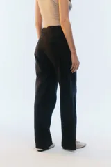 Pantalón de lino color tostado, de tiro alto y corte amplio con perneras rectas. Cuenta con pasacintos, bolsillos laterales y bolsillos traseros con solapa.
