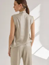 Top sin mangas de lino en color beige con acabado ligeramente brillante, cuello en V y corte recto.