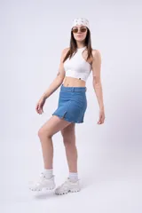 Minifalda de jean azul claro, tiro bajo, con aberturas frontales en el ruedo.