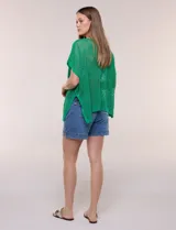 Poncho de tejido calado color beige, con mangas cortas, aberturas laterales y lazos ajustables en el cuello. Modelo Do Everything In Love.