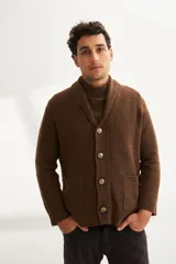 Cardigan tejido color marrón con cuello smoking, cierre con botones y bolsillos delanteros.