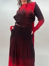 Falda larga de crepe de lana, teñida con degradado de bordó oscuro a rojo. Presenta bolsillos laterales y tablas.
