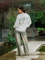 Camisa de lino con diseño de cuadrillé en tonos blanco y beige, de manga larga y cuello clásico. Presenta una pequeña estampa en el pecho y una estampa en la espalda, con un calce holgado y relajado.