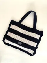 Bolso tipo tote tejido a crochet con hilo de algodón color marrón y crudo, con diseño a rayas horizontales y volados en los bordes.