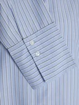 Camisa de popelín blanca de manga larga con cuello clásico y cierre frontal de botones ocultos, de ajuste relajado y puños anchos.