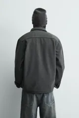 Sobrecamisa de corte regular confeccionada en tejido con estructura diagonal repelente al agua. Presenta cuello solapa, cierre frontal con botones, mangas largas con puños abotonados y bolsillos plastrón con solapa en el pecho.
