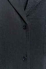 Camisa fluida de viscosa con cuello solapa de muescas, manga larga con puños y bolsillo de plastrón en el pecho. Cierre frontal con botones.