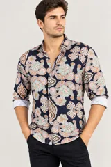 Camisa de hombre con cuello italiano y mangas largas, con un estampado arabesco en tonos naranjas, celestes y blancos sobre base azul marino.