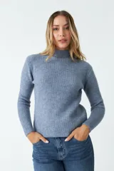 Sweater de tejido de punto acanalado en color azul grisáceo, con cuello redondo y mangas largas. Presenta un ajuste regular y una pequeña grifa de cuero con logo en el lateral.