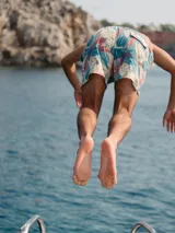 Short de baño color gris con estampado de palmeras, cintura elástica con cordón ajustable y tres bolsillos.