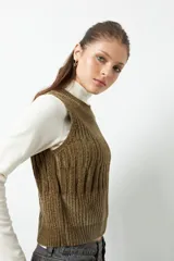 Chaleco de punto color crema con cuello alto y diseño tramado vertical.