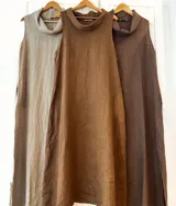 Vestido largo de lino con cuello caído, sin mangas y corte recto. Presenta un diseño minimalista y fluido, ideal para diversas ocasiones.