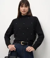 Suéter Cortelle de punto color negro, con cuello alto, mangas largas, diseño de rombos en relieve y aplicación de pequeños strass distribuidos en el frente.