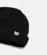 Gorro tipo fisherman de tejido acrílico con textura acanalada, diseño corto y etiqueta pequeña con logo en el frente.