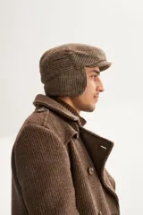 Boina marrón con orejeras y diseño a cuadros.