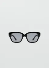 Lentes de sol con armazón de policarbonato negro y diseño cuadrado.