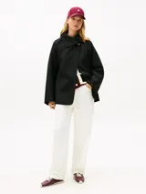 Abrigo oversize Tommy Hilfiger de mezcla de lana de doble cara en color negro, con cuello chimenea, cierre de botones dorados y bolsillos delanteros de parche.