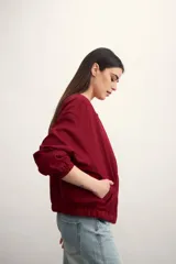 Chaqueta tipo bomber color negro, con cierre frontal metálico, cuello redondo y puños elásticos.