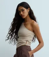 Blusa de un solo hombro color beige, confeccionada en crepé con diseño ajustado y detalle fruncido con abertura en el lateral.