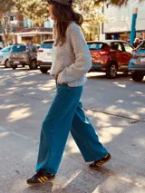 Pantalón de jean ancho de color azul, con bordado de las iniciales AW en el bolsillo trasero.