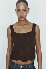 Top corto de tejido de punto color marrón oscuro, con escote cuadrado y tirantes anchos. Presenta un detalle de calado tipo crochet en el ruedo con borde festoneado.