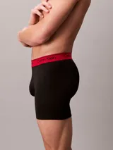 Pack de tres boxers largos Calvin Klein confeccionados en microfibra elástica. Presentan una cintura elástica con el logo de la marca en contraste, disponible en tres colores diferentes: negro con letras blancas, negro con letras negras y negro con letras rojas.