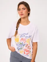 Remera celeste de corte holgado, con cuello redondo, manga corta y estampado frontal colorido de temática costera.