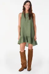 Vestido corto lila de lino, sin mangas, con escote redondo, cartera de botones de nácar en el frente y volado fruncido en el ruedo.