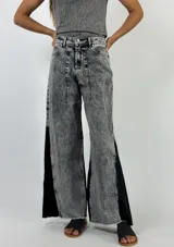 Pantalon de jean de corte recto y tiro alto, con efecto de lavado ácido y franjas laterales en denim de color azul oscuro. Presenta ruedo deshilachado.