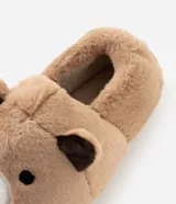 Pantufla cerrada de peluche color tostado con diseño de cara de oso en la parte frontal y orejas pequeñas. Cuenta con suela de goma antideslizante y forro interior suave.