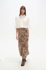 Falda larga de corte recto con abertura lateral pronunciada, confeccionada en tejido fluido con estampado abstracto en tonos tierra y crema.