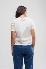 Remera blanca de algodón con estampado pequeño de una estrella roja en el pecho.