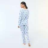 Pijama de dos piezas compuesto por una remera de manga larga y un pantalón largo, ambos en color celeste con estampado integral del personaje Stitch y pequeños corazones negros. La remera presenta el nombre del personaje en el frente.
