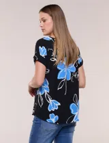 Blusa de silueta holgada y recta, confeccionada en crepe de poliéster con estampado animal print. Presenta escote redondo clásico, mangas cortas de hombro caído con puño doblado y ruedo ligeramente curvo.